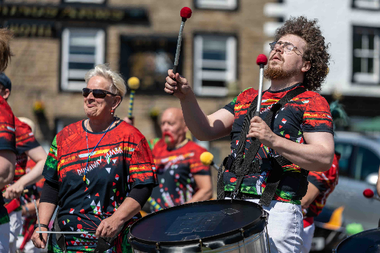 people walking a the street and drumming